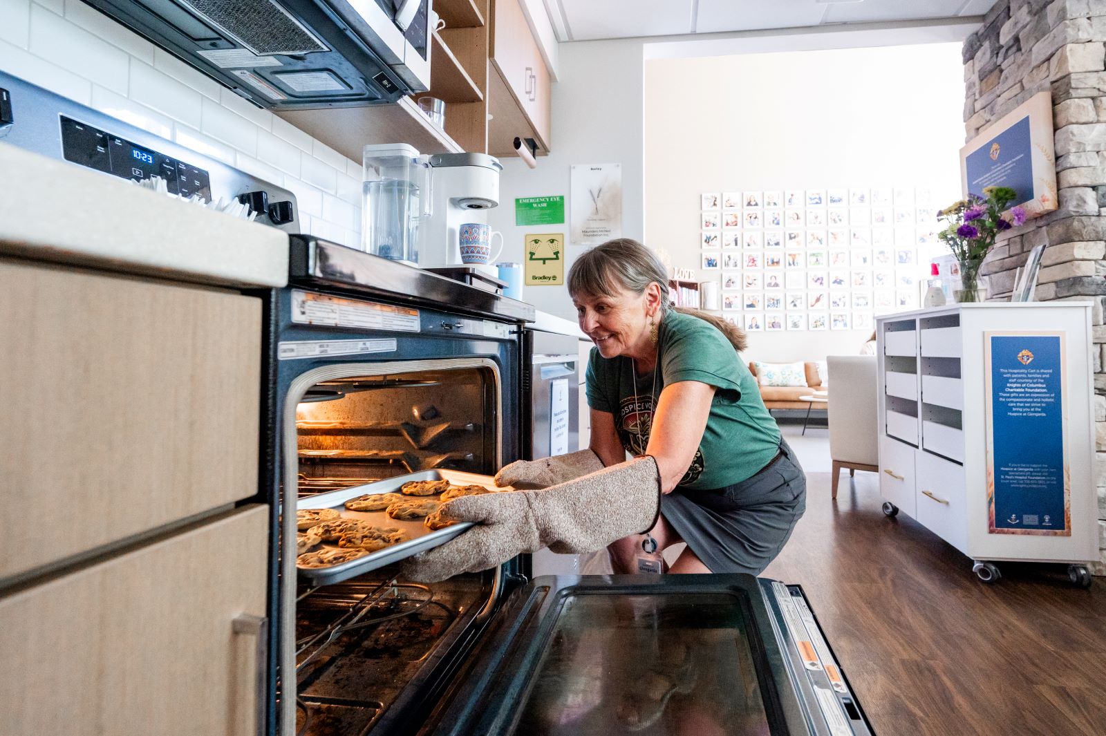 A volunteer takes cookies out of the oven at the Hospice at Glengarda.